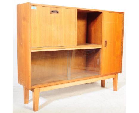 A vintage mid 20th century teak wood book case display cabinet. Of rectangular form with a series of drawers and cupboards, a