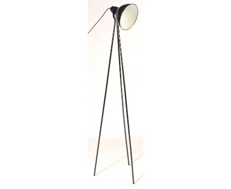 A contemporary tripod photo set floor standing lamp. Having a conical shade with three ebonised metal tubular legs. Comes wit