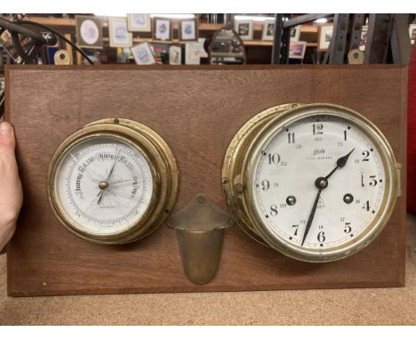 A BRASS BAROMETER AND CLOCK ON A WOODEN BASE 