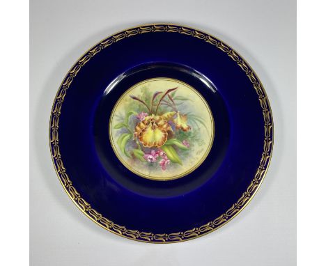 A ROYAL WORCESTER HAND PAINTED PORCELAIN PLATE, SIGNED J.PRICE DEPECITING FLOWERS AGAINST A COBALT BLUE GROUND WITH GILT DESI
