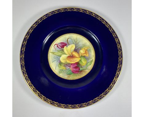 A ROYAL WORCESTER HAND PAINTED PORCELAIN PLATE, UNSIGNED, DEPECITING FLOWERS AGAINST A COBALT BLUE GROUND WITH GILT DESIGN BO