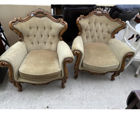 A PAIR OF ITALIAN STYLE EASY CHAIRS WITH CARVED SCROLL AND BUTTON BACKS, ON CABRIOLE LEGS 