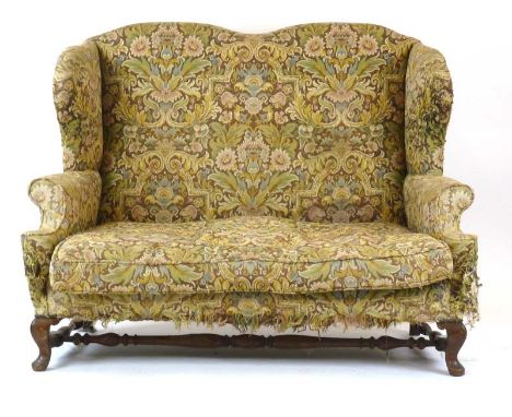 An 18th/19th century and later wingback sofa of Georgian twin-backed design on a mahogany frame with turned feet and a cross 