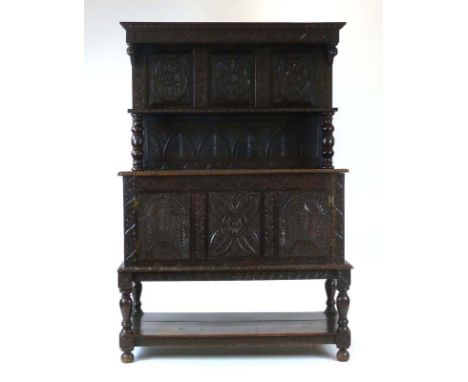 A Victorian 17th century-type carved oak dresser, the panelled back over a shelf and three doors on turned and carved support