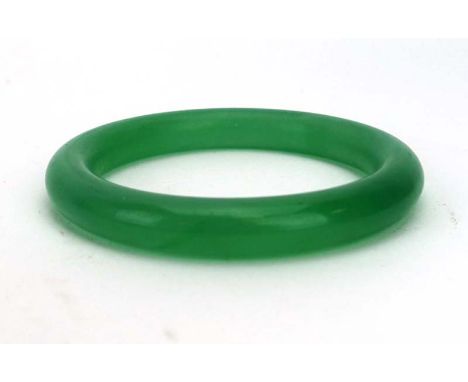 A green jade bangle, internal d. 5.7 cm CONDITION REPORT: We cannot make a judgement as to weather this bangle has been dyed 
