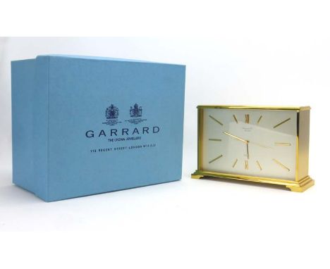 A 1980's Swiss mantle clock, the face with Roman numerals, within a brass case, retailed by Garrard & Co., London, h. 13 cm, 