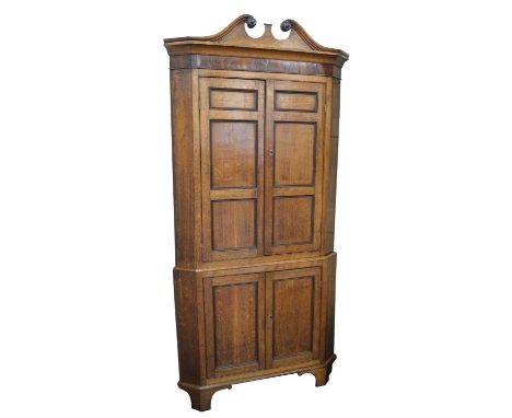 George III oak floor standing corner cupboard George III oak floor standing corner cupboard, swan neck pediment, cornice vene