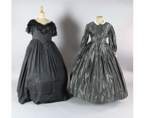La Traviata: A rail with a collection of 19th century style dresses in black velvet, grey silk, a white and mushroom cotton d