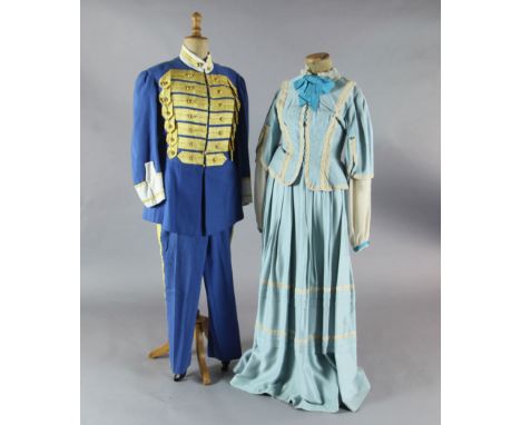 Rigoletto: A rail with a pale blue skirt and jacket, a quantity of royal blue gold braided jackets and trousers, similar red 