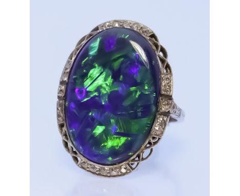 An Opal and Diamond Ring, in platinum mount, set with a black opal, 23mm x 16mm, surrounded by twenty small diamonds, size O,