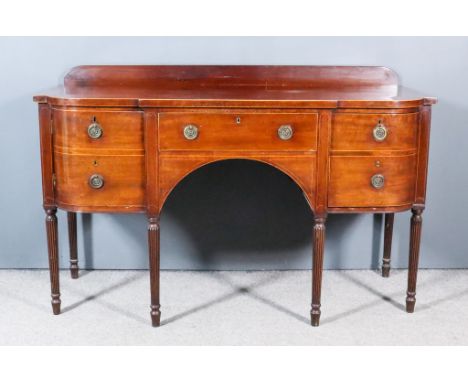 A Late George III Mahogany Bow and Breakfront Sideboard, inlaid with boxwood stringings with low back panel, fitted central d