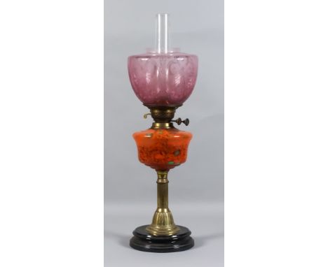 An English Veritas Oil Lamp, Late 19th Century, the orange marbled glass reservoir with gilt metal column on black glazed sto