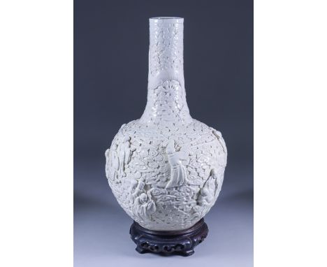 A Chinese White Glazed Porcelain Bottle Shaped Vase, Late 19th/20th Century, moulded in relief with dragons amongst clouds an