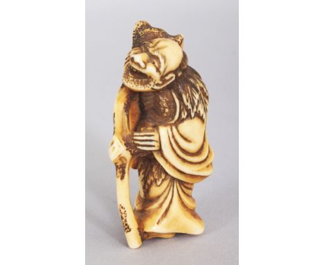 A GOOD JAPANESE EDO PERIOD IVORY NETSUKE OF A SENNIN, with upturned cheerful expression and leaning on a curved and knarled s