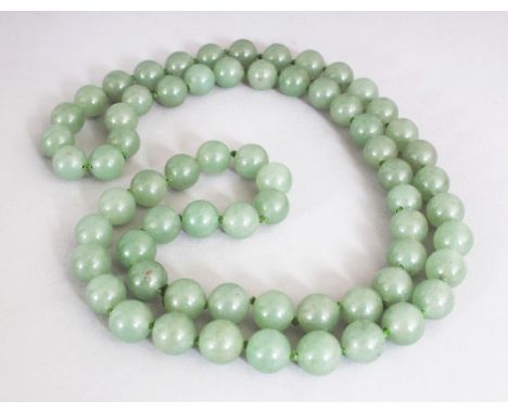 A JADE-LIKE GREEN HARDSTONE NECKLACE, composed of spherical beads, approx. 28in long.