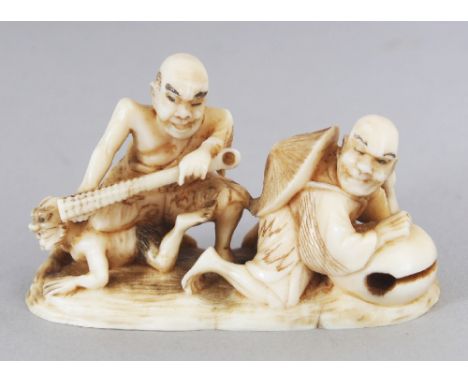 A SIGNED JAPANESE MEIJI PERIOD IVORY NETSUKE OF TWO MEN, one subduing an oni, the other leaning on a temple bell, the base wi