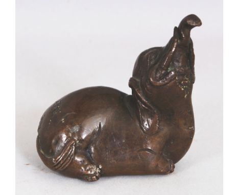 A 16TH/17TH CENTURY CHINESE MING DYNASTY BRONZE SCROLL WEIGHT, modelled in the form of a mythical Baku elephant, the creature