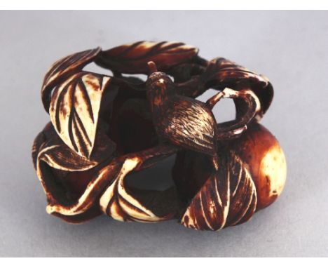 A JAPANESE MEIJI PERIOD STAINED IVORY NETSUKE, carved and pierced in the form of a bird perched on a stem of a cluster of fru
