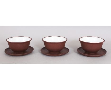 A GROUP OF THREE EARLY/MID 20TH CENTURY CHINESE YIXING POTTERY TEABOWLS & SAUCERS, the interior of each teabowl glazed in whi