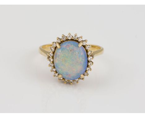 OPAL RING GG 750. Ringmaß ca. 57.5. Ges.-Gew.: ca. 5.3 g. Ein ovaler Opal Cabochon ca. 12 x 10 mm und 24 Brillanten mit einem