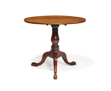 A George III oak and elm tilt top occasional table, circa 1770, the circular top above a turned pillar and tripod base, 73cm 