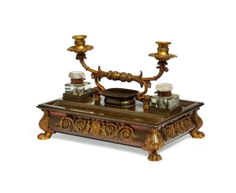 A large Regency gilt and patinated bronze and brass desk stand, circa 1815, the rectangular section body mounted with twin sc