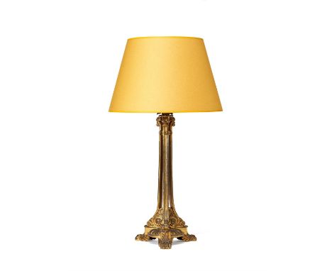 A George IV gilt metal oil lamp base, circa 1830 and later refitted for electricity, the frame cast with upright supports and