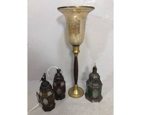 Three eastern design metal candle lanterns with coloured glass panels and a brass mounted standard storm lantern of colonial 