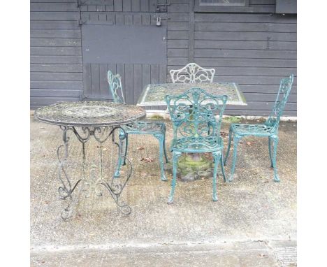 A green painted cast iron garden table, 88cm diameter, together with a set of four chairs and another table