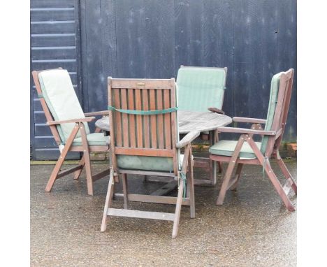 A teak circular garden table, together with four teak folding garden chairs, with green cushionsTable 130w x 130d x 65h cm