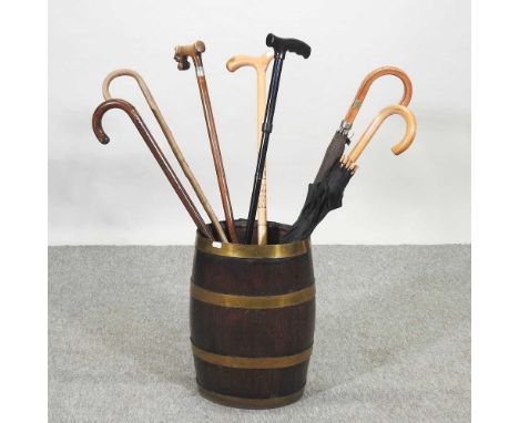 A collection of walking sticks, contained in a coopered barrel stick stand