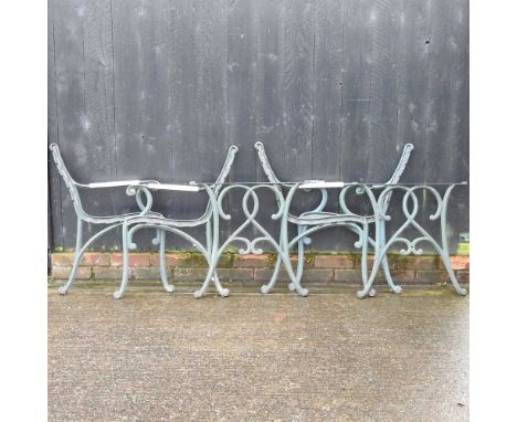 Two pairs of metal garden bench ends, 64 x 64cm, together with a pair of garden table supports