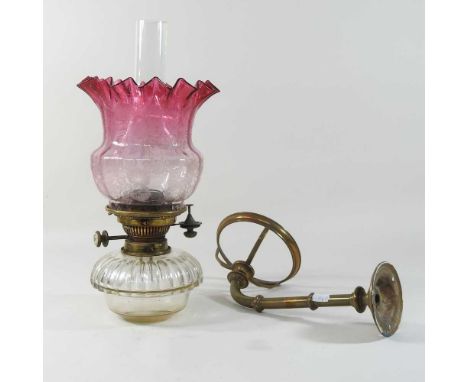 An early 20th century Hinks patent wall light, with a glass reservoir and an etched glass shade40cm high overall