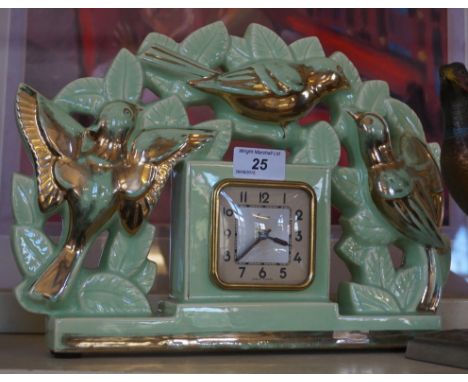 A French Art Deco gilt and green glazed ceramic mantel clock, relief decorated with birds and foliate.