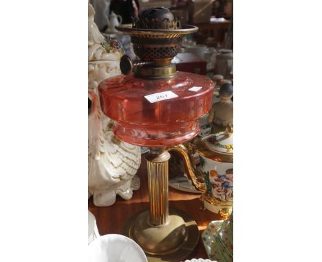 A Victorian cranberry glass paraffin lamp.