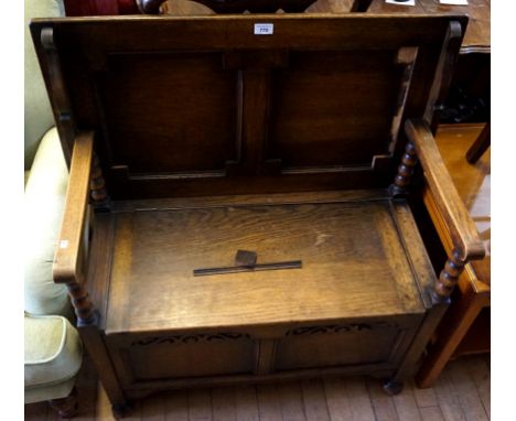 An early 20th Century oak monks bench, the seat lifts to form storage area, having blind fret decoration.