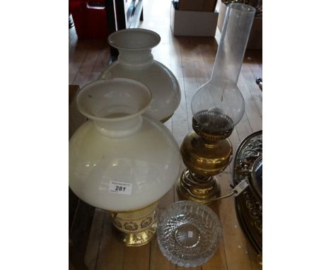 Two ceramic and brass lamp bases together with a brass paraffin lamp and a cut glass ashtray.