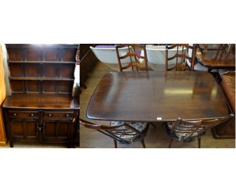 An Ercol dark elm dining suite comprising refectory dining table, four ladderback dining chairs, sideboard with plate rack ba