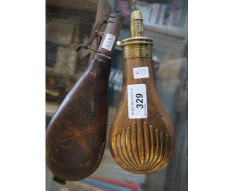 A Vintage brass and cooper powder flask together with a leather example.