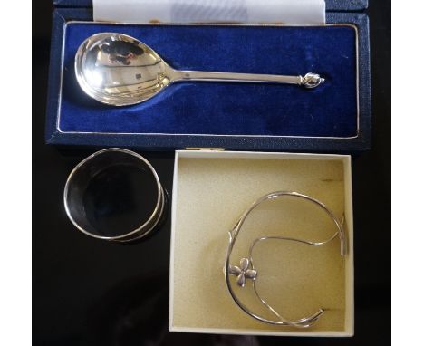 A cased hallmarked silver copy of 'The Writhen Spoon', an engine turned hallmarked silver napkin ring, a silver and diamond c