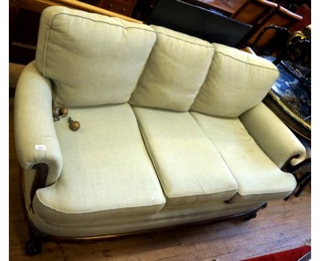 An early 20th Century Bergere three seater sofa, raised on ball and claw supports.