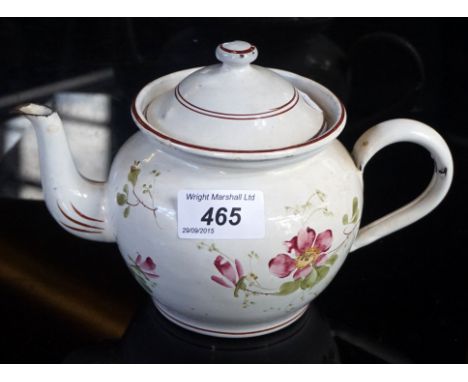 A 19th Century French enamel teapot of bulbous form, hand painted with floral decoration on a white tin ground, height 14cm.