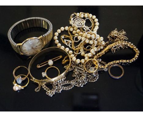 A collection of costume jewellery to include an opal bar brooch, a pearl ring, a moonstone ring, a gold plated hinged bangle,