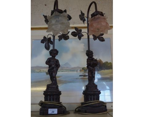 A pair of modern table lamps in the form of putti, with rose effect style lamp shades.