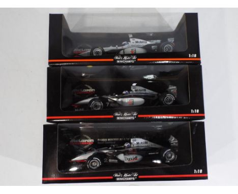 Minichamps - three 1:18 scale diecast F1 cars by Minichamps with a McLaren theme, models appear in mint condition in mint box