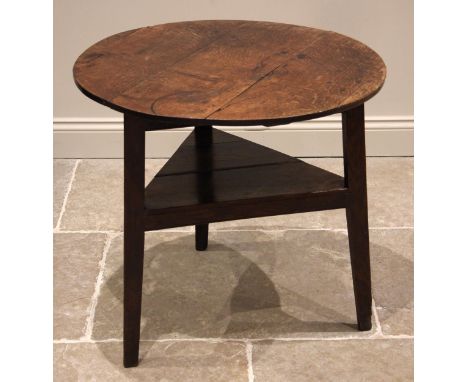 A 19th century oak cricket table, the circular plank top upon three chamfered supports, united by a triangular under tier, 69