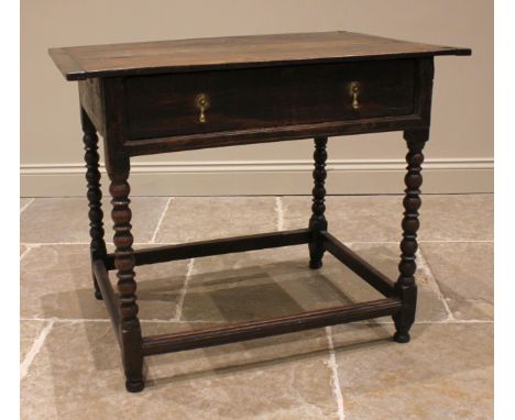 An 18th century oak side table, the cleated plank top over a single oak lined frieze drawer, upon bobbin turned supports unit
