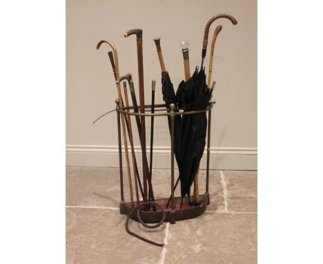 A collection of walking sticks, canes and parasols to a Victorian brass stick stand, to include; a 'Waterloo, Rifle Brigade' 