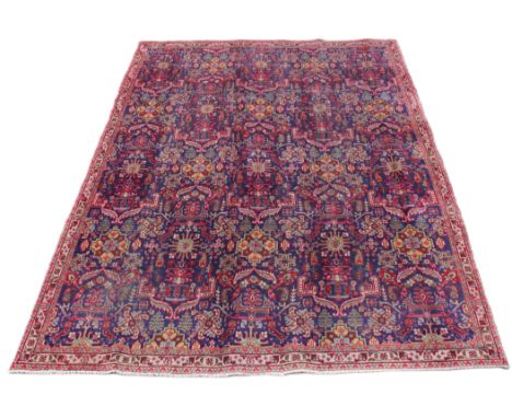 A vintage blue ground Persian Tabriz carpet, with a traditional all over geometric design enclosed by a red ground repeating 