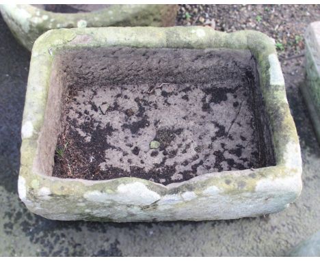 A 19th century rectangular sandstone trough planter, 27cm H x 60cm W x 44cm D, along with a sandstone grindstone, 52cm diamet